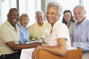 Group Of Senior Friends Having Lunch Together At A Restaurant Smiling at camera